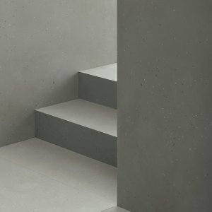 רצפת Primavera Nero עם קיר Grigio וכורסת עור